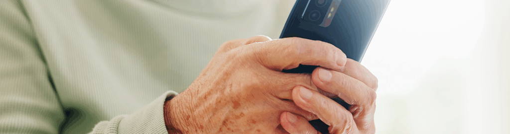 close-up on an older adult who uses their phone to search for a senior living community